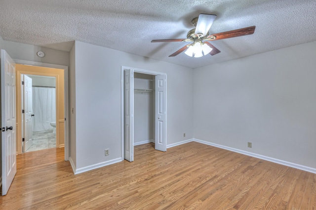 unfurnished bedroom featuring ceiling fan, a textured ceiling, a closet, and light wood-type flooring