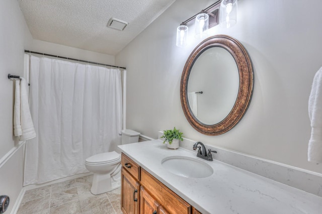 bathroom with vanity, toilet, and a textured ceiling