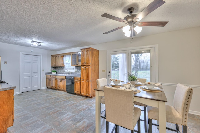 kitchen featuring sink, a breakfast bar area, dishwasher, tasteful backsplash, and a textured ceiling