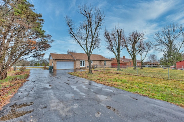 ranch-style house featuring a garage and a front lawn