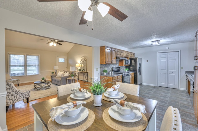 dining area with a textured ceiling, dark hardwood / wood-style floors, and ceiling fan