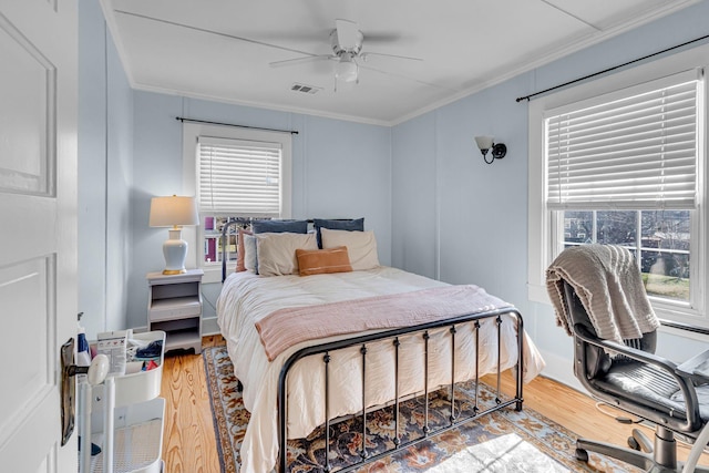 bedroom with ceiling fan, ornamental molding, and wood-type flooring