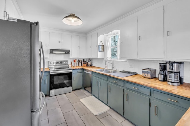 kitchen with white cabinetry, appliances with stainless steel finishes, sink, and butcher block countertops