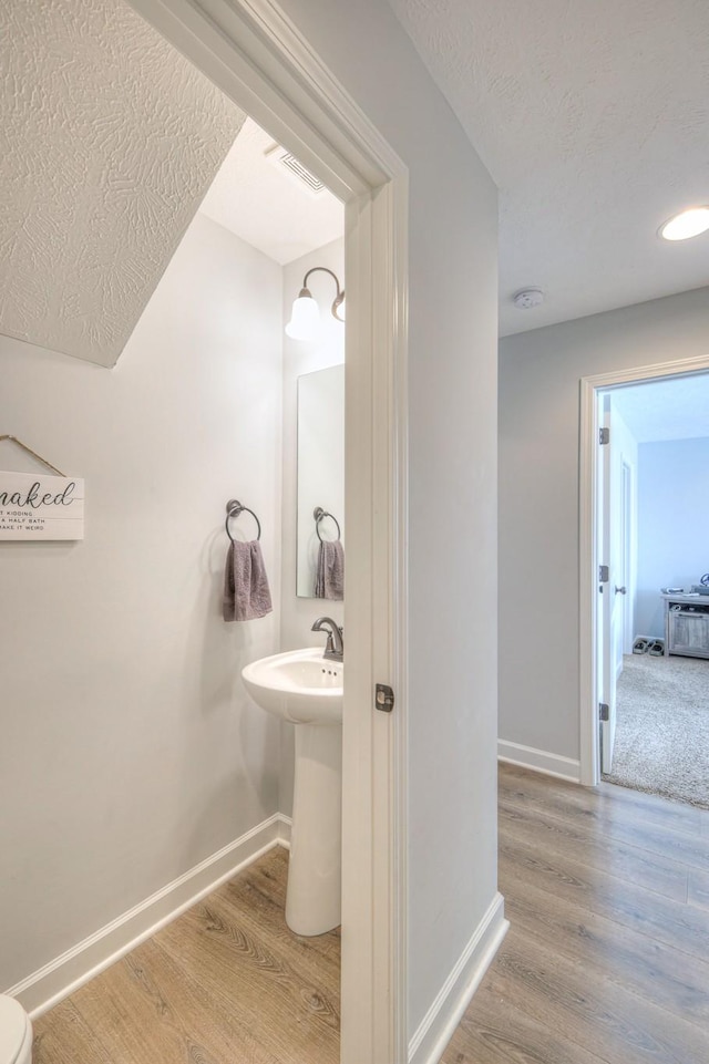 bathroom featuring a textured ceiling and hardwood / wood-style floors