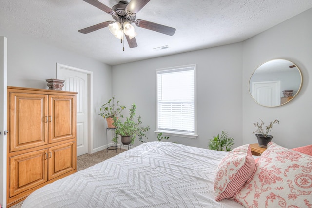 bedroom with a textured ceiling, light carpet, and ceiling fan