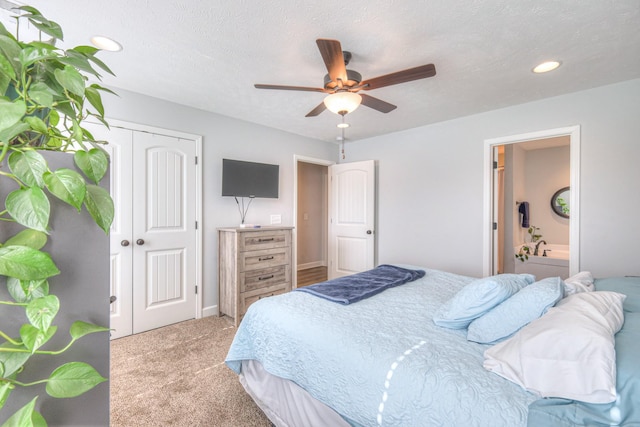 bedroom with light colored carpet, a closet, ceiling fan, a textured ceiling, and ensuite bathroom