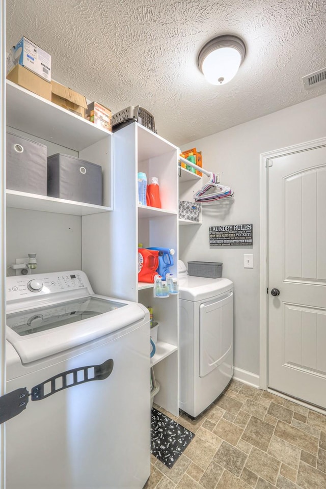 laundry area featuring separate washer and dryer and a textured ceiling