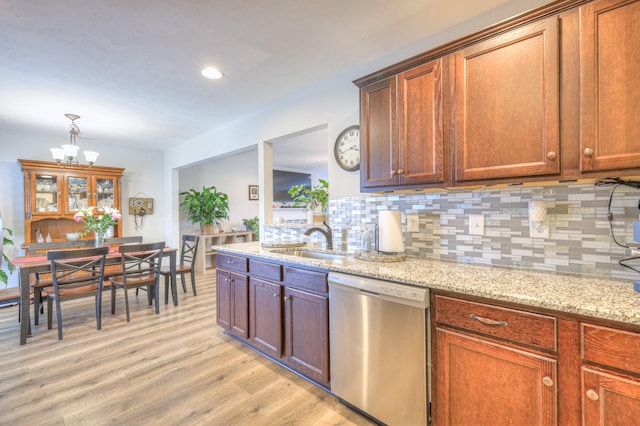 kitchen with sink, light wood-type flooring, dishwasher, light stone countertops, and tasteful backsplash