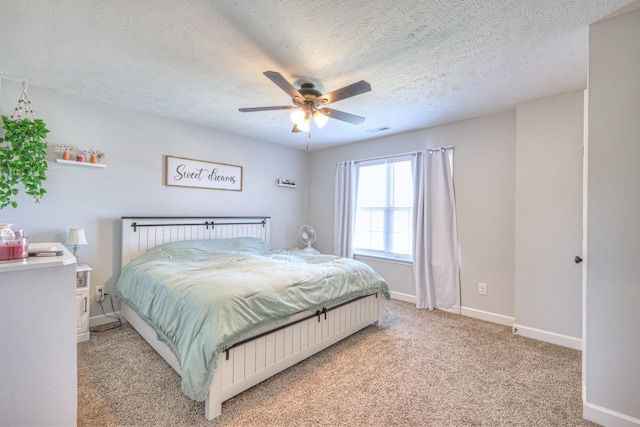 bedroom with a textured ceiling, light carpet, and ceiling fan