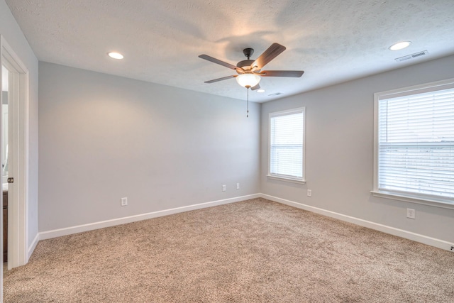 empty room with a ceiling fan, light carpet, baseboards, and visible vents