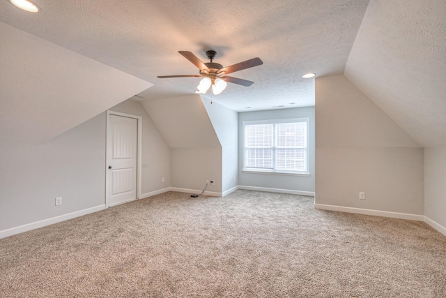 bonus room with baseboards, ceiling fan, carpet, and a textured ceiling
