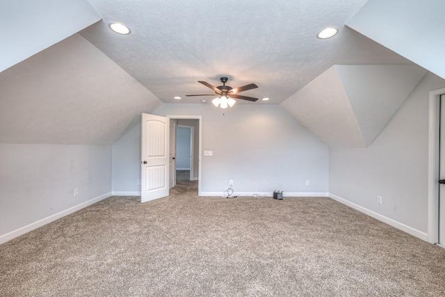 bonus room featuring baseboards, lofted ceiling, a textured ceiling, and a ceiling fan