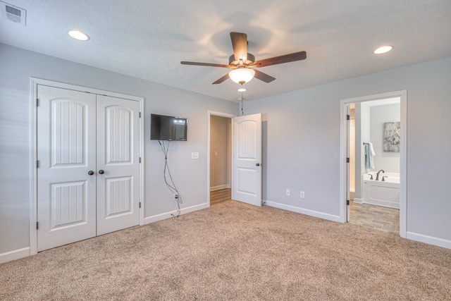 unfurnished bedroom with baseboards, carpet floors, ensuite bath, visible vents, and a closet