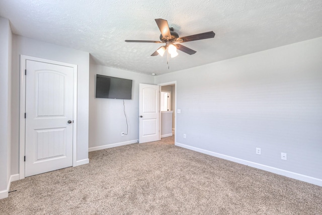 unfurnished bedroom with baseboards, a ceiling fan, carpet floors, and a textured ceiling