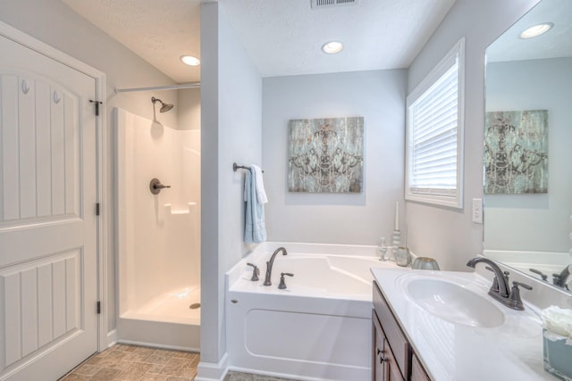bathroom with vanity, a garden tub, a shower stall, a textured ceiling, and visible vents