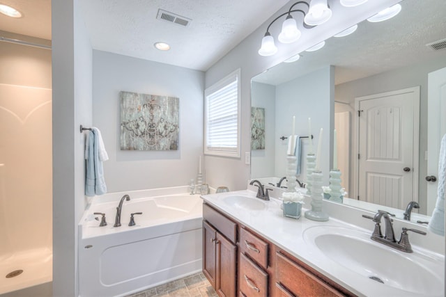 bathroom with a sink, a textured ceiling, and visible vents