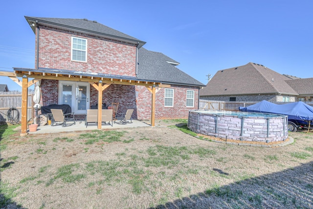 rear view of property with a patio, brick siding, and a yard