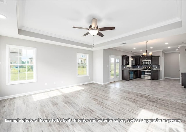 unfurnished living room with crown molding, a tray ceiling, and light hardwood / wood-style flooring