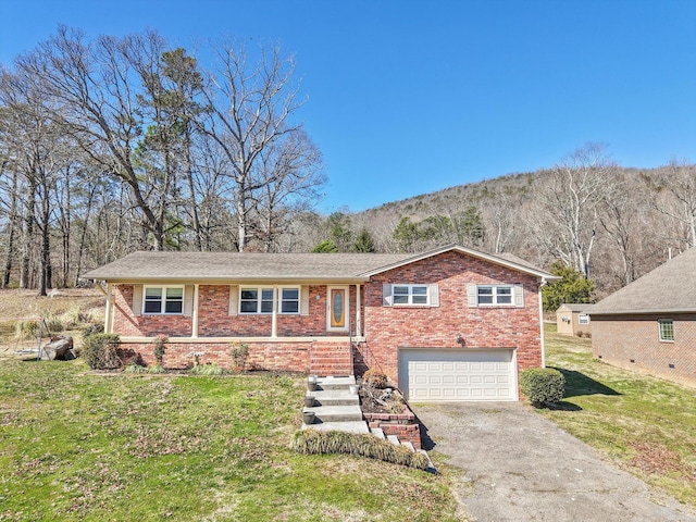 view of front of home featuring a garage, aphalt driveway, brick siding, and a mountain view