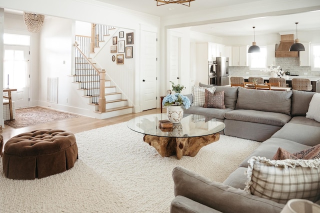 living room with crown molding and light hardwood / wood-style floors