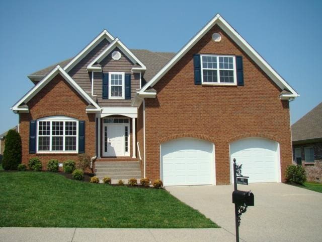 view of front of house with a garage and a front lawn