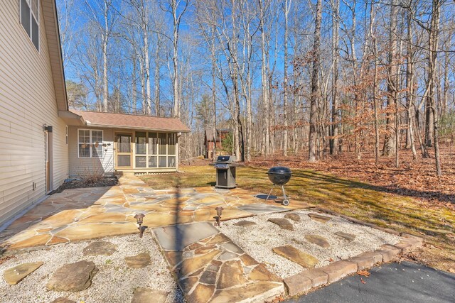 view of patio with grilling area and a sunroom