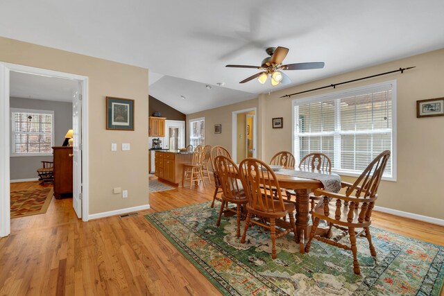 dining room featuring light hardwood / wood-style floors, lofted ceiling, and ceiling fan