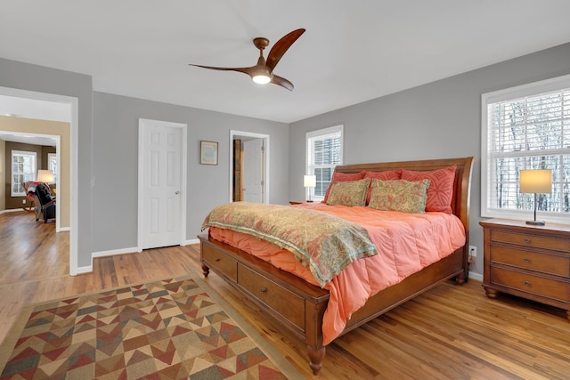 bedroom featuring multiple windows, ceiling fan, and light wood-type flooring