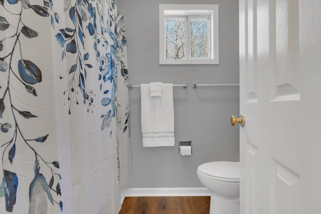 bathroom featuring toilet, a shower with shower curtain, and wood-type flooring