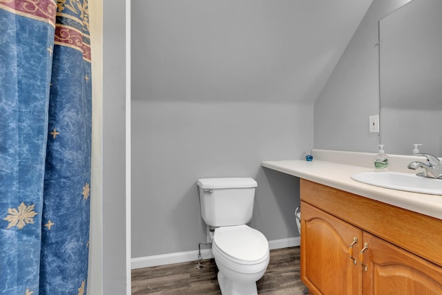 bathroom featuring toilet, lofted ceiling, wood-type flooring, and vanity