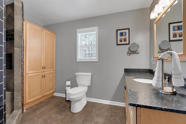 bathroom with tile patterned floors, toilet, vanity, and walk in shower