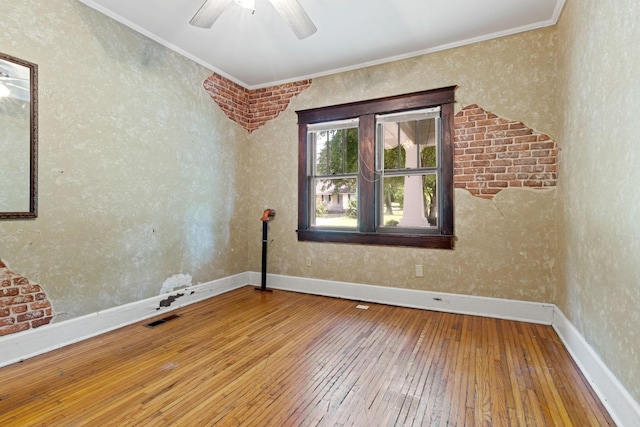 empty room featuring ornamental molding, wood-type flooring, and ceiling fan