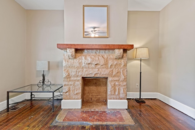 interior details featuring hardwood / wood-style flooring and a stone fireplace