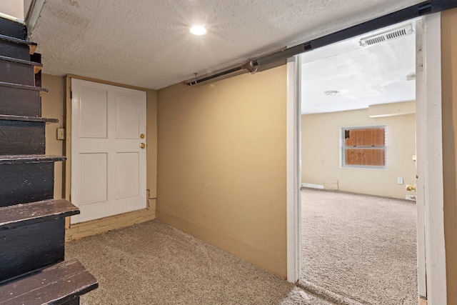 basement with light colored carpet and a textured ceiling