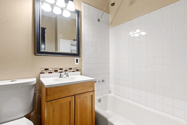 full bathroom featuring vanity, tiled shower / bath, backsplash, and toilet