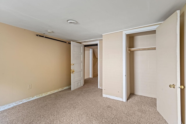 unfurnished bedroom featuring light colored carpet and a closet