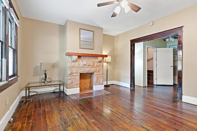 unfurnished living room featuring dark hardwood / wood-style flooring, a fireplace, and ceiling fan