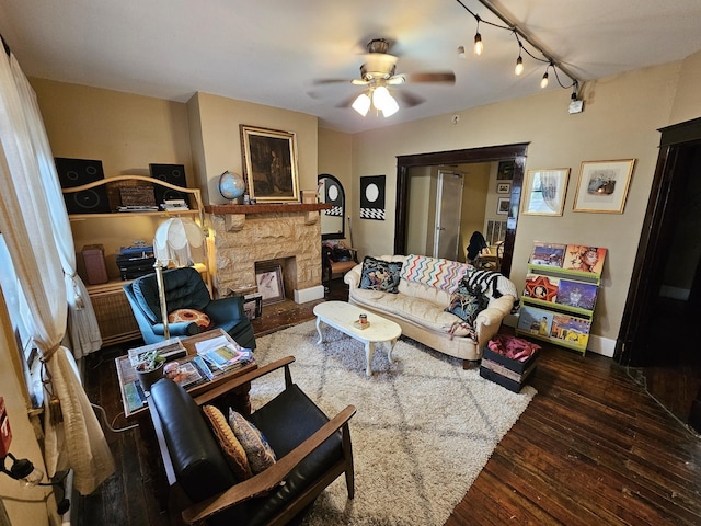 living room featuring dark wood-type flooring, ceiling fan, and a fireplace