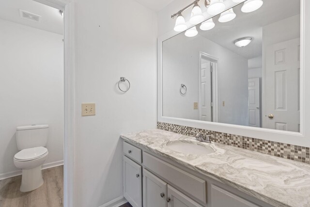 474 S Main St Unit 203, Ashland City, TN 37015 - bathroom featuring vanity, hardwood / wood-style flooring, tasteful backsplash, and toilet