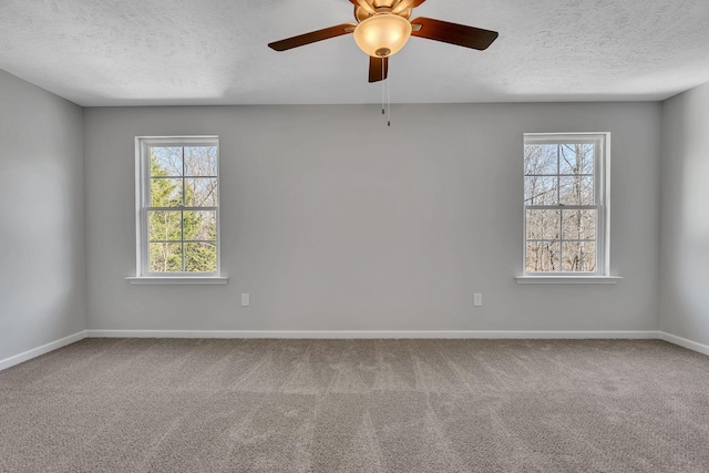 carpeted spare room with a textured ceiling, ceiling fan, plenty of natural light, and baseboards