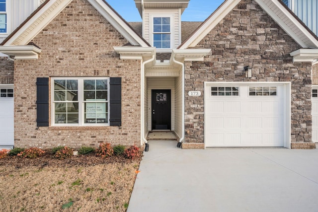 view of front of house with a garage, concrete driveway, and brick siding