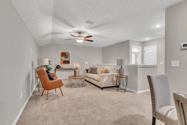 living room featuring attic access, baseboards, visible vents, light colored carpet, and a textured ceiling