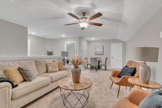 living room featuring a ceiling fan, recessed lighting, light colored carpet, and a textured ceiling