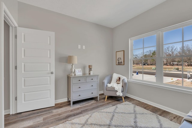 sitting room with baseboards and light wood-style floors