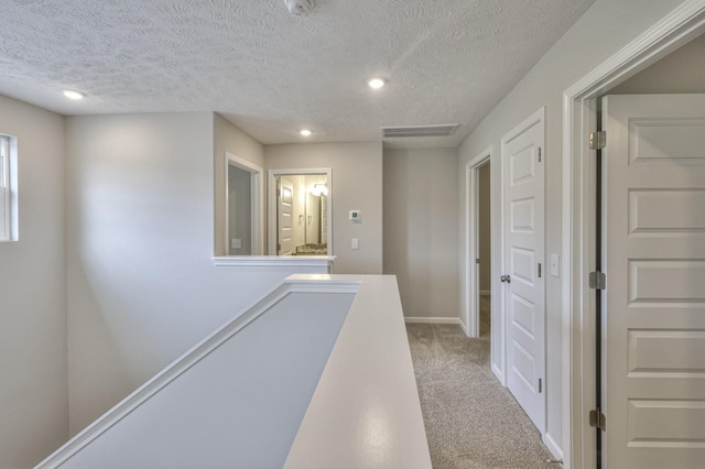 hallway featuring recessed lighting, visible vents, carpet flooring, an upstairs landing, and baseboards