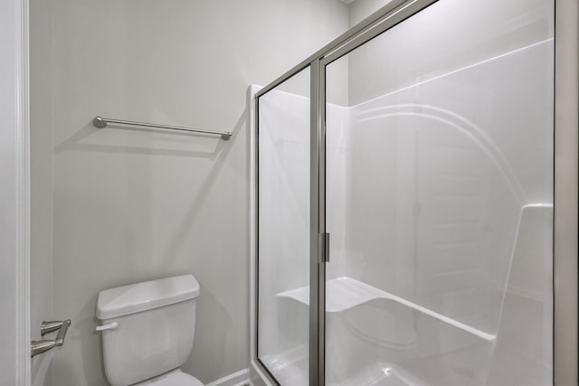 bathroom with a stall shower and toilet