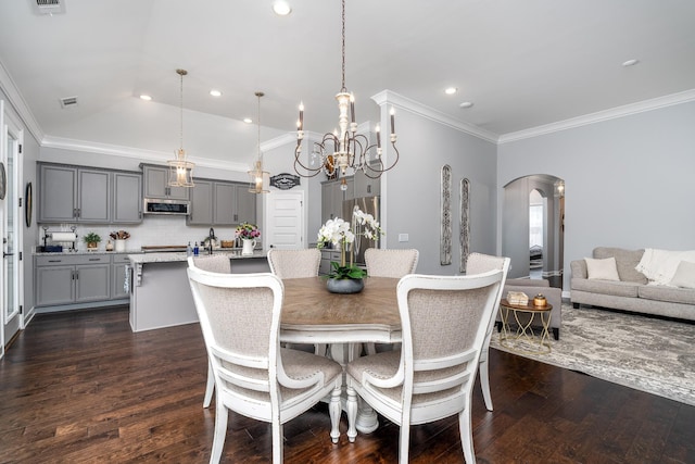 dining space with crown molding, vaulted ceiling, and dark hardwood / wood-style floors