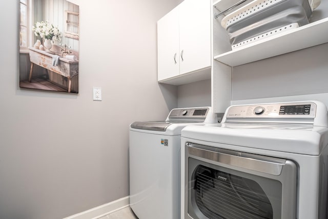 laundry area featuring separate washer and dryer and cabinets