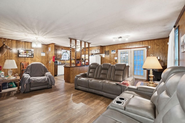 living room featuring wooden walls, hardwood / wood-style floors, and a textured ceiling