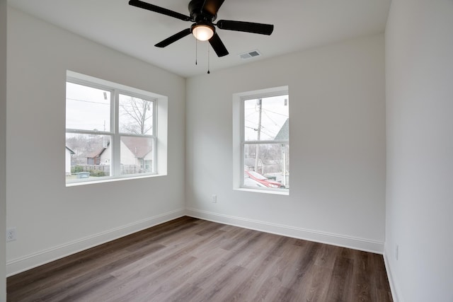 unfurnished room with a healthy amount of sunlight, hardwood / wood-style floors, and ceiling fan